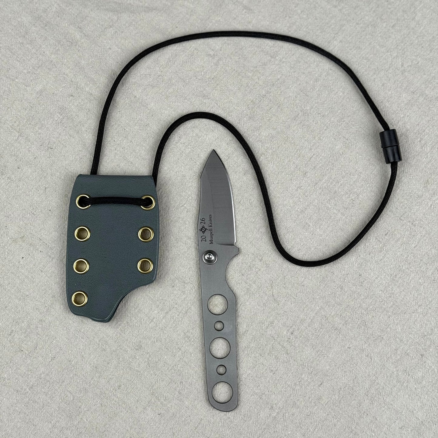 944 mk 2 neck knife with large gray sheath, black string, brass eyelets