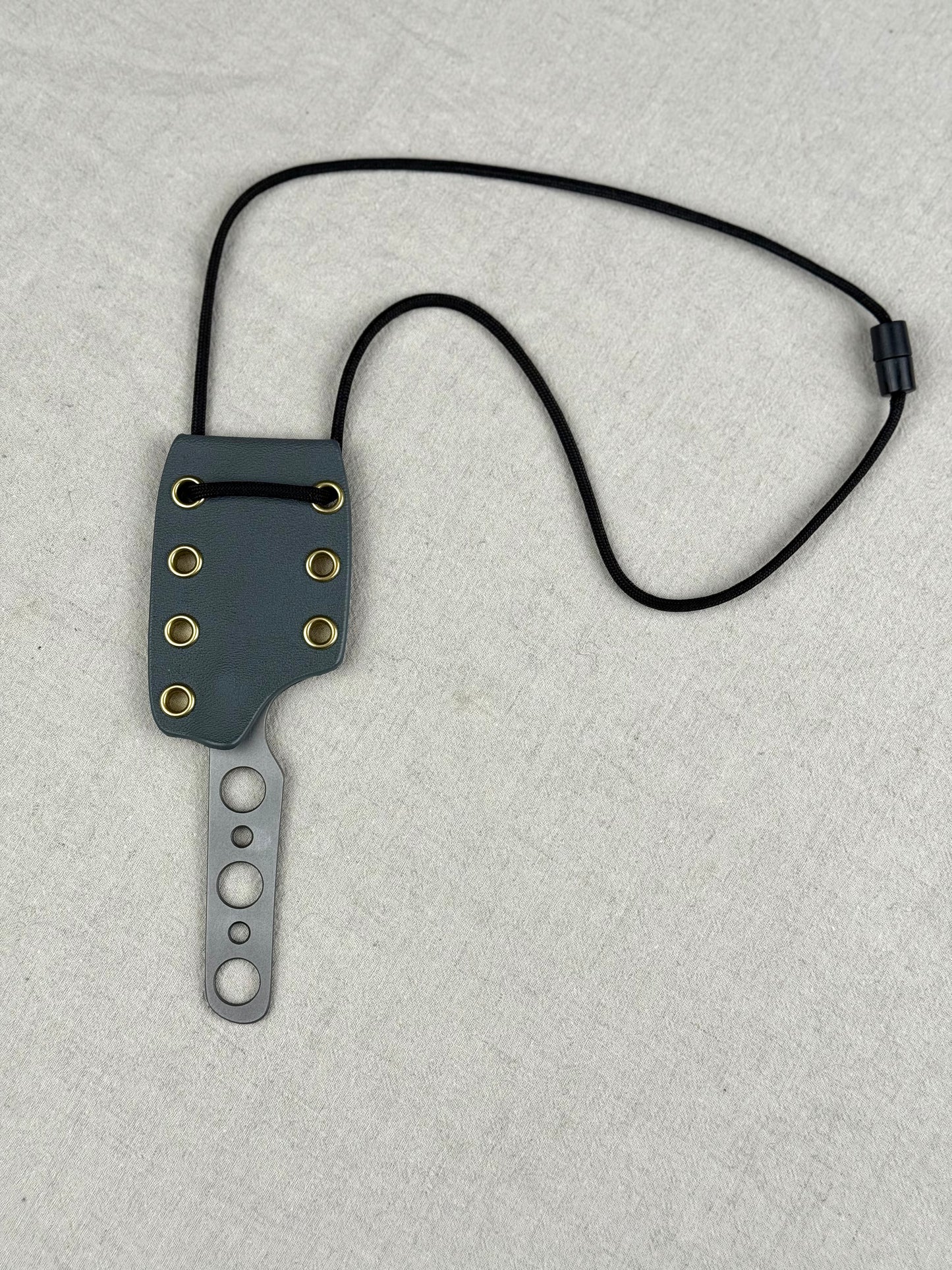 944 mk 2 neck knife with large gray sheath, black string, brass eyelets