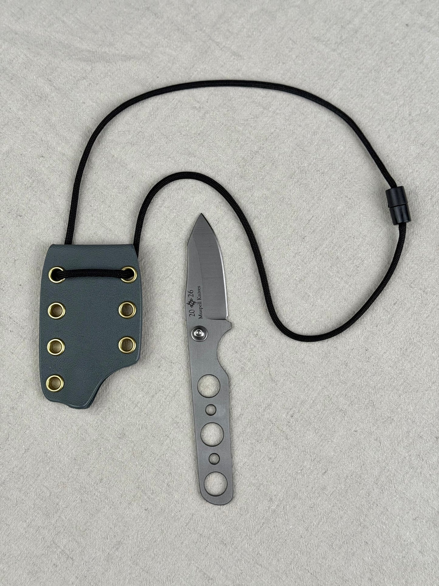 944 mk 2 neck knife with large gray sheath, black string, brass eyelets